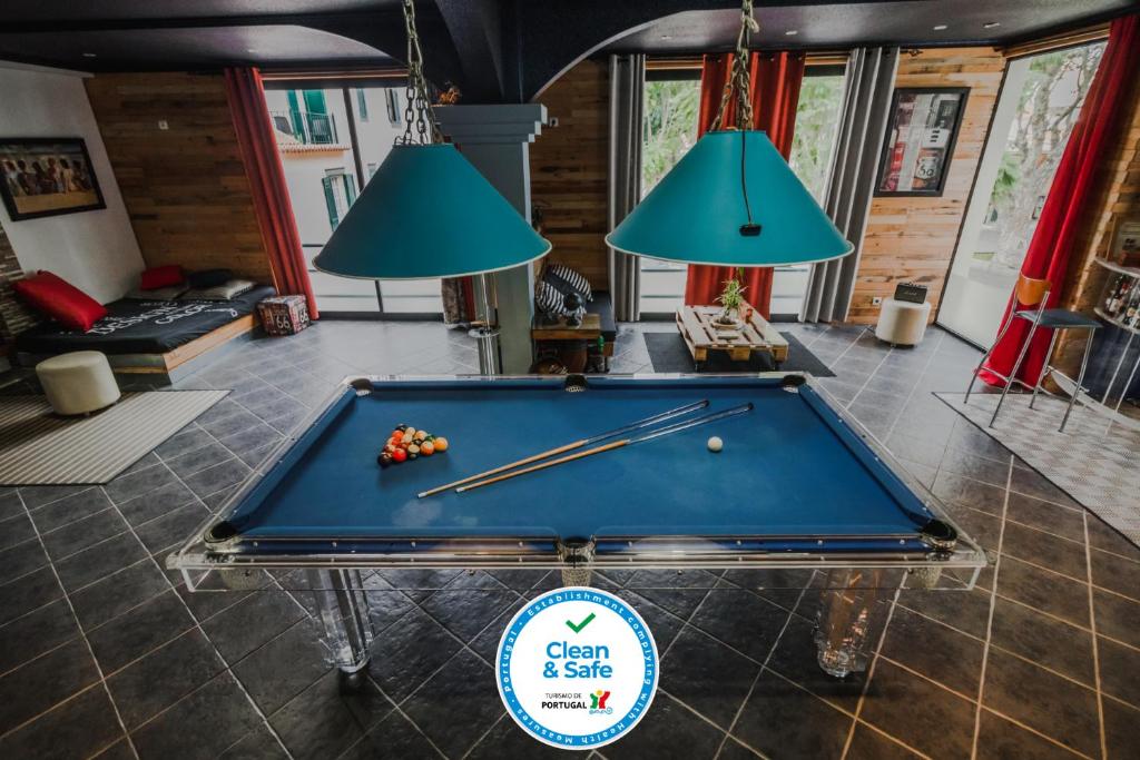 a pool table in a room with two lamps at The Modern & Recycled House in Machico