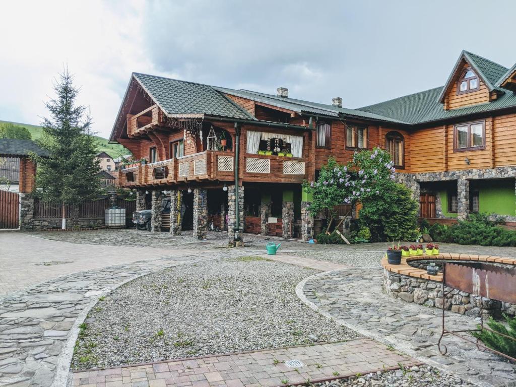 a large wooden house with a stone path in front of it at У Ірини in Yasinya