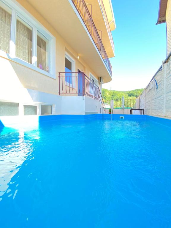 uma piscina numa casa com água azul em Ambassador Guest House em Lazarevskoye