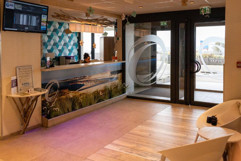 a restaurant with a fish tank in the middle of a lobby at The Originals Boutique, Hôtel Neptune, Berck-sur-Mer in Berck-sur-Mer