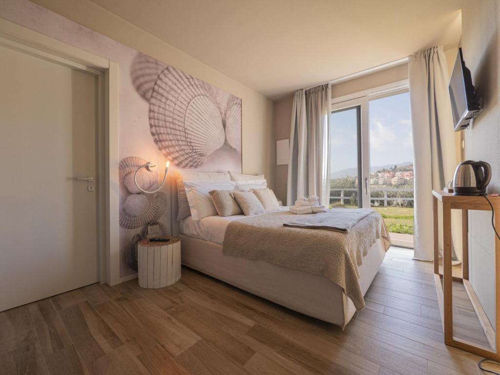 een slaapkamer met een groot bed en een groot raam bij Agriturismo Terre degli Angeli in Pietra Ligure