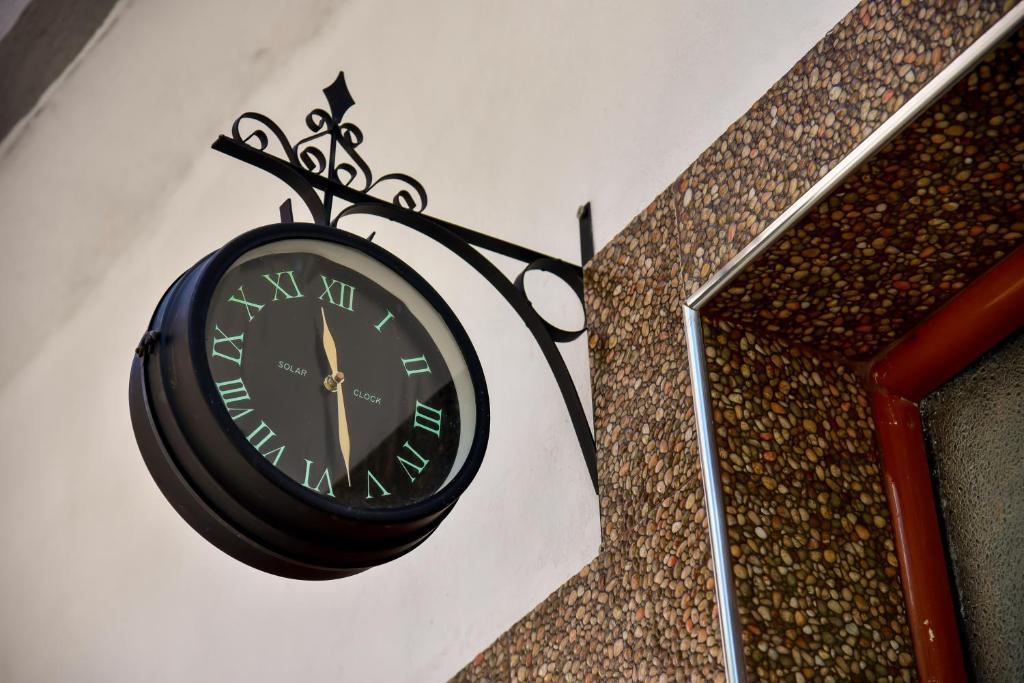 un reloj negro colgando en el costado de una pared en THE OLD TOWN CLOCK en Gjirokastër