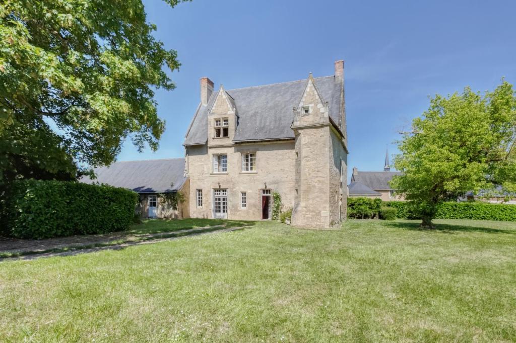 una vecchia casa in pietra con un ampio cortile di Le Castel a Montigné-les-Rairies