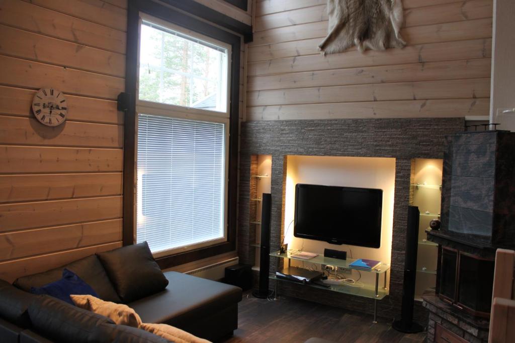 a living room with a couch and a flat screen tv at Levi Unelma Villa in Levi