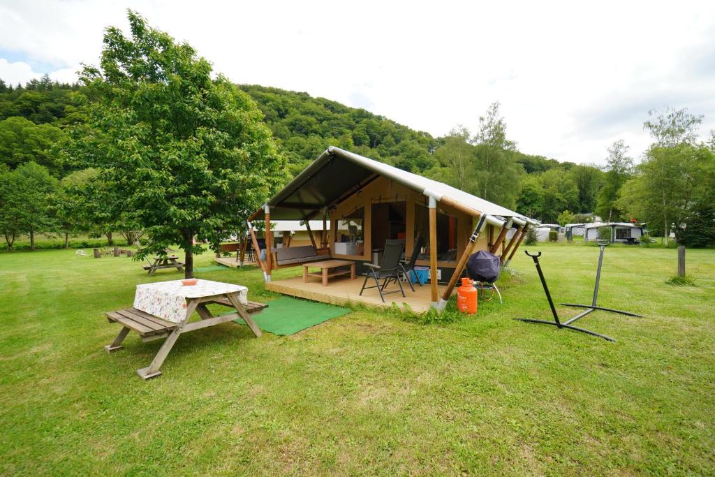 eine kleine Hütte mit einem Picknicktisch und einem Zelt in der Unterkunft Safaritent op Camping Berkel in Bockholtz