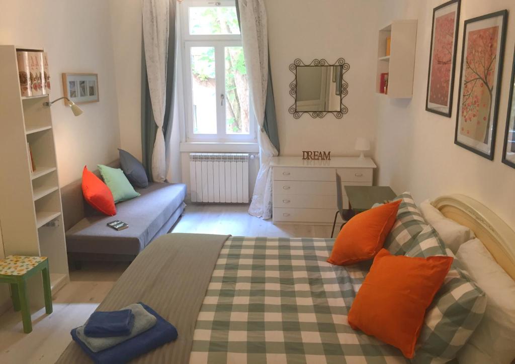a bedroom with a bed and a couch and a window at Rivabahn in Trieste