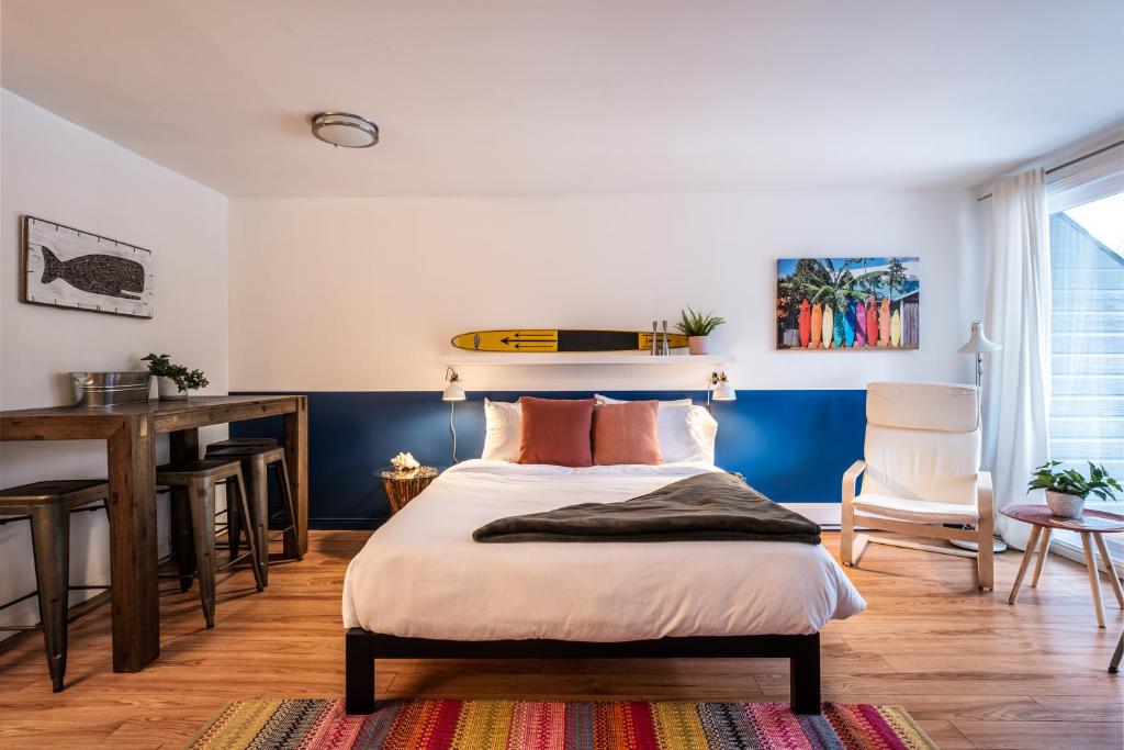 Schlafzimmer mit einem Bett mit einem Surfbrett an der Wand in der Unterkunft Tremblant Studio Kona by My Tremblant Location in Mont-Tremblant