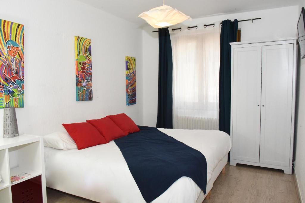a bedroom with a bed with red and blue at Hotel de la Placette Barcelonnette in Barcelonnette