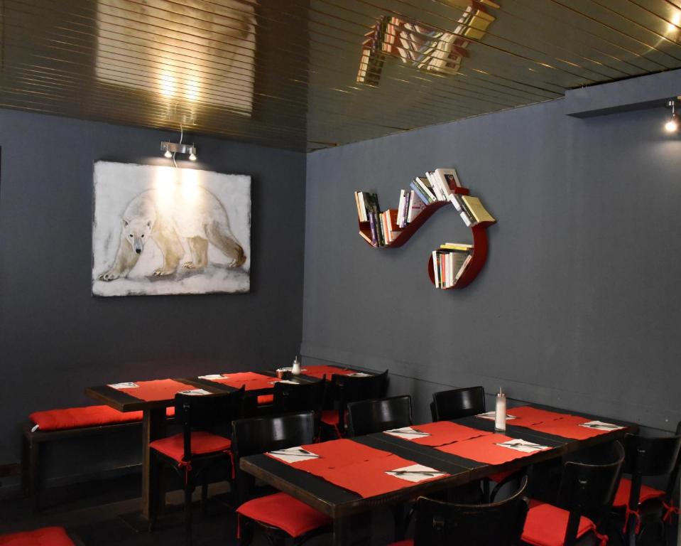 a dining room with tables and a painting of a polar bear on the wall at Hotel de la Placette Barcelonnette in Barcelonnette