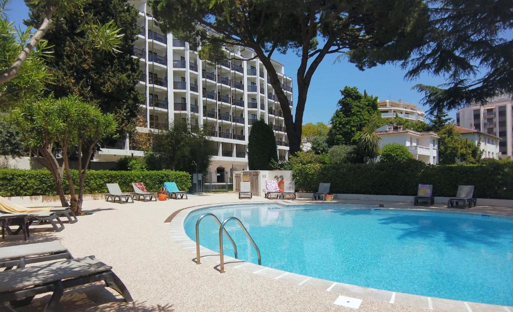 une grande piscine avec un bâtiment en arrière-plan dans l'établissement Résidence Residéal Premium Cannes, à Cannes