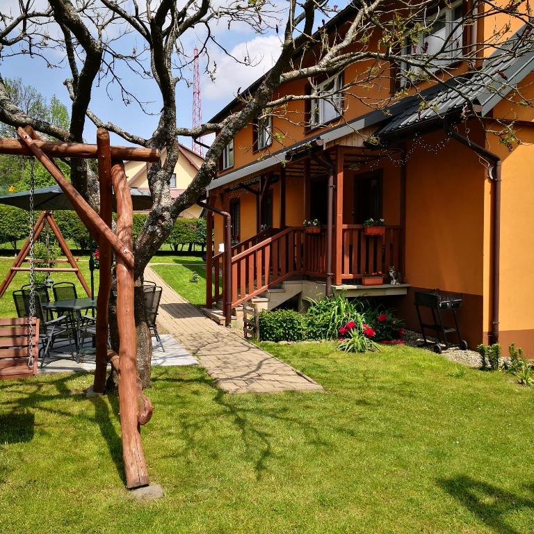 dom z ogrodem z drzewem w obiekcie Apartament Na Rozdrożu w Cisnej