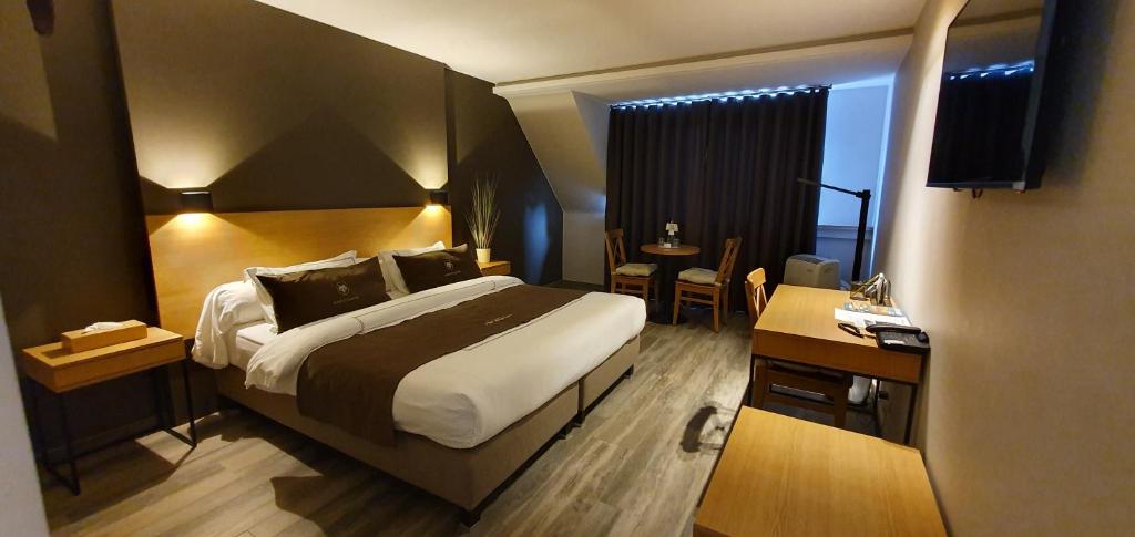 a hotel room with a large bed and a desk at Hotel The New Fox in Affligem