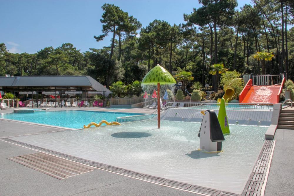 a swimming pool with two people in it at Océan Vacances - Camping Paradis in Saint-Georges-de-Didonne