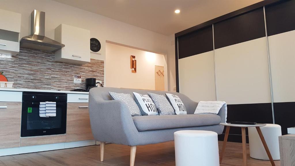 ein Wohnzimmer mit einem Sofa und einer Küche in der Unterkunft Apartments GLORIJA in Pula