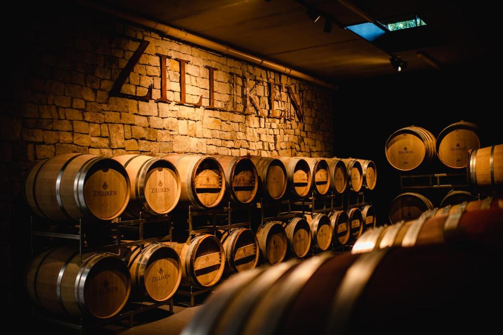 uma fila de barris de vinho numa sala com uma parede de tijolos em Weingut und Gästehaus Zilliken em Nittel