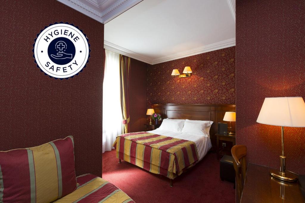 a hotel room with a bed and a sign on the wall at Elysees Niel Hotel in Paris