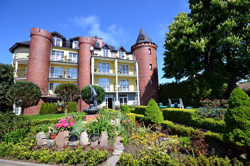 un castillo con jardín frente a un edificio en PANORAMA Mielno, en Mielno