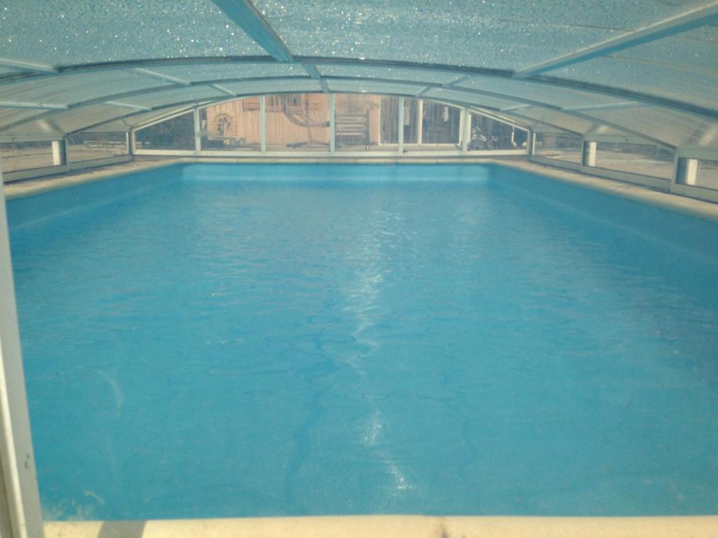 uma grande piscina de água azul num edifício em MAISON LOFT avec beaucoup de charme em Muret