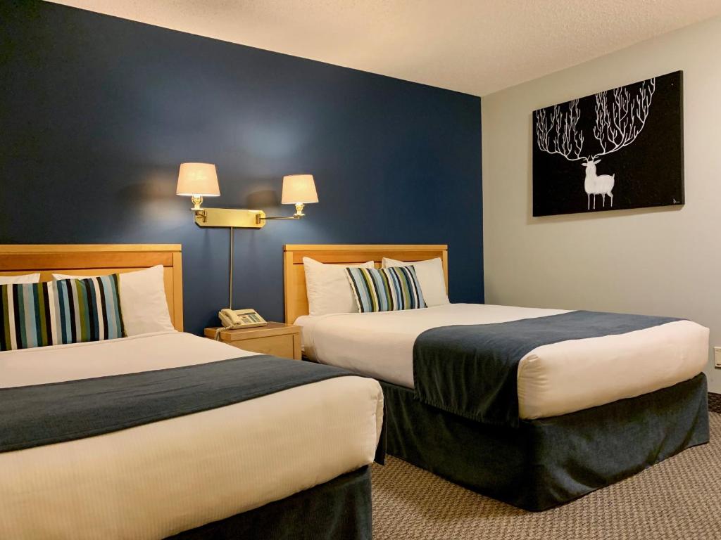 AltonaにあるAltona Hotelのベッド2台が備わる客室で、壁には絵画が飾られています。