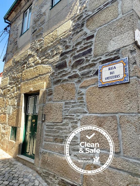 a stone building with a sign on the side of it at Casa da Lurdinhas in Tabuaço