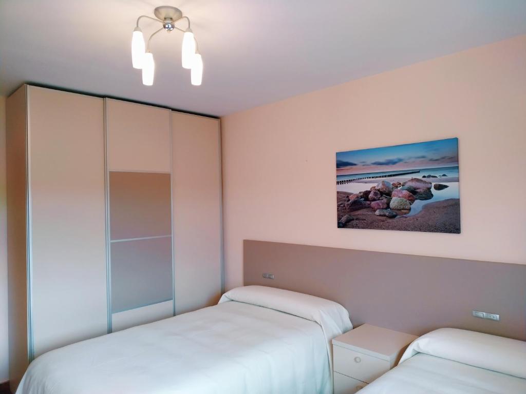 2 camas en una habitación con paredes blancas en Tentempé Peregrino, en Barreiros