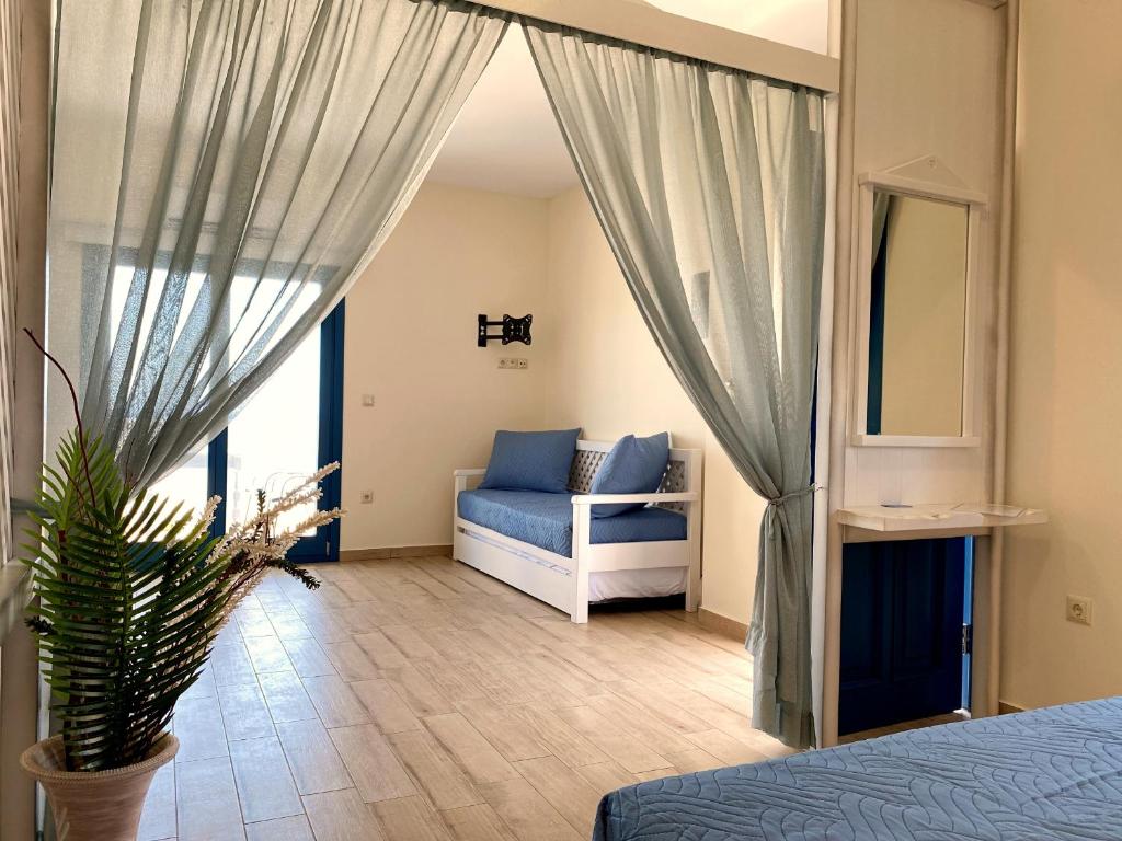 ein Schlafzimmer mit einem Bett, einem Sofa und einem Spiegel in der Unterkunft Michail Suites Afiartis Karpathos in Karpathos