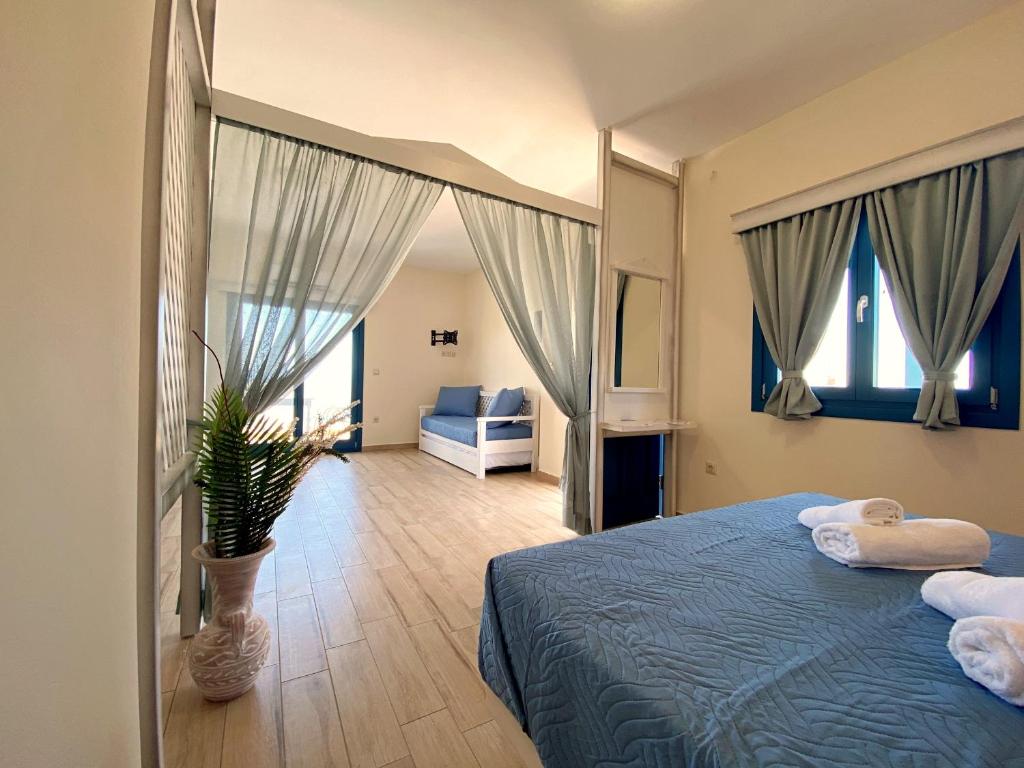 ein Schlafzimmer mit einem blauen Bett und einer Topfpflanze in der Unterkunft Michail Suites Afiartis Karpathos in Karpathos