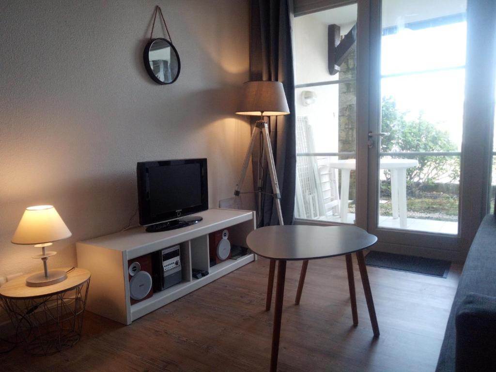 un salon avec une télévision et une table dans l'établissement Studio cabine Arzon Crouesty 4p, à Arzon
