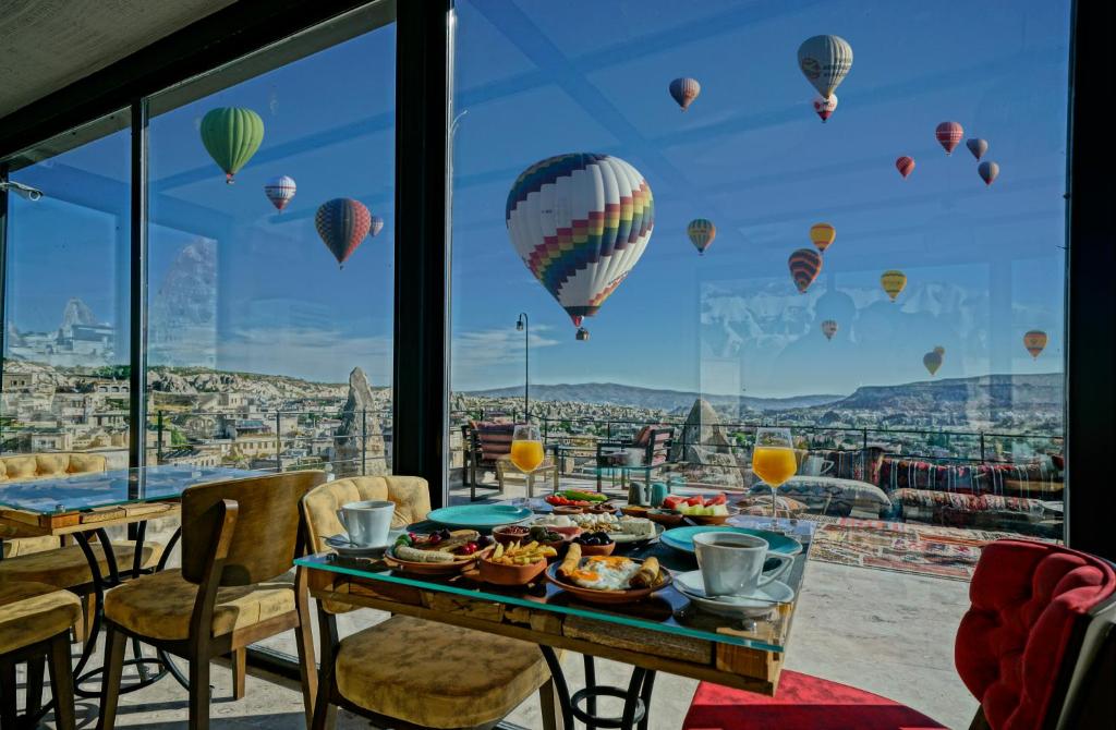 een tafel met voedsel en luchtballonnen in de lucht bij Arinna Cappadocia in Goreme