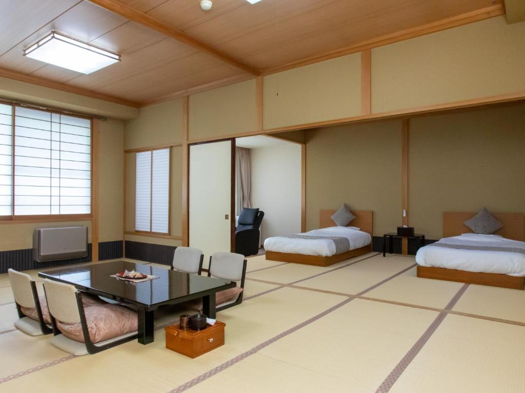 Postel nebo postele na pokoji v ubytování Tabist Koboshi no Yu Senshintei Aizu Yunokamionsen