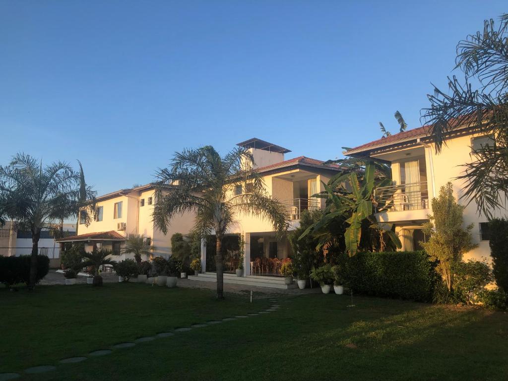 a large house with a lawn in front of it at Valparaiso Hotel in Cruz das Almas