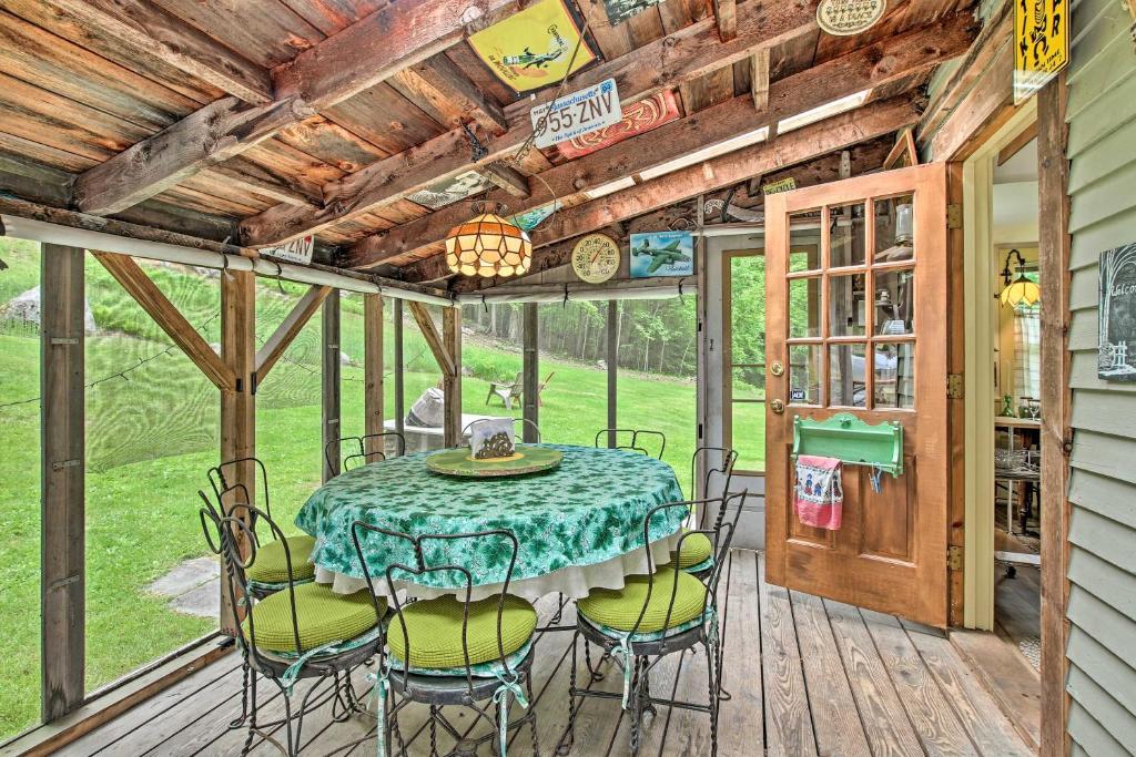 eine Terrasse mit einem Tisch und Stühlen auf einer Terrasse in der Unterkunft Rustic-Chic Cottage with Yard and Grill - Near Hiking! in Northfield