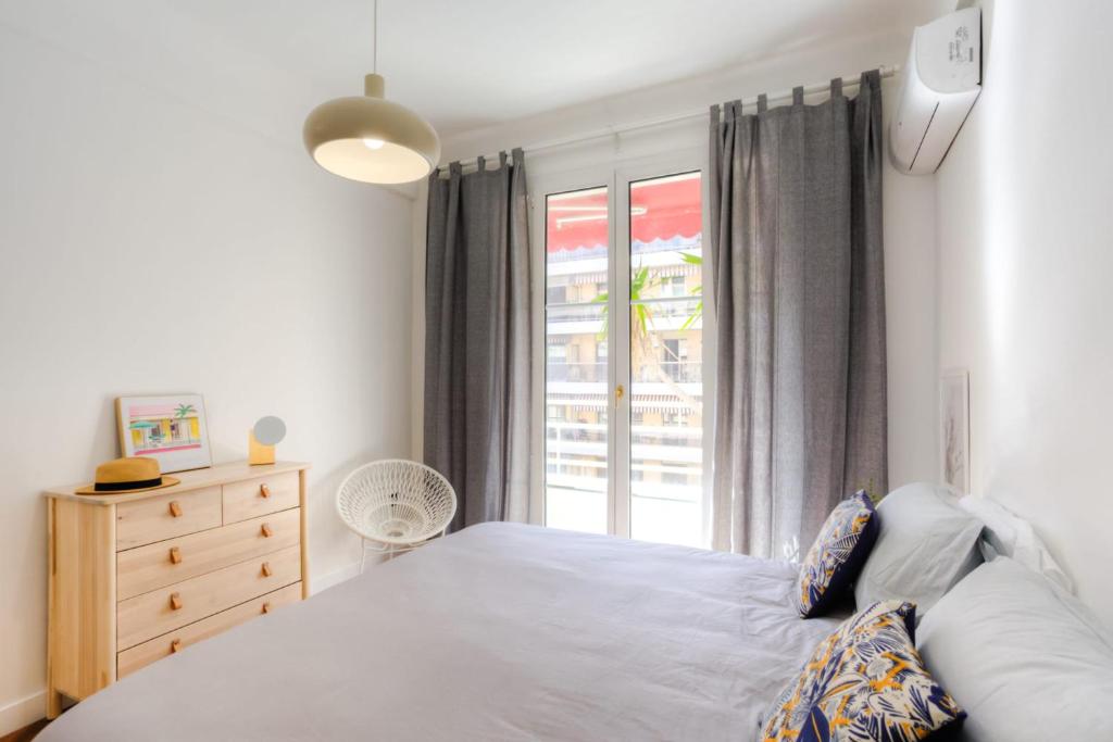 a bedroom with a white bed and a window at #29 Suite Gambetta AC Sea view 2 bedrooms 1min Walk to Promenade &amp; Sea in Nice