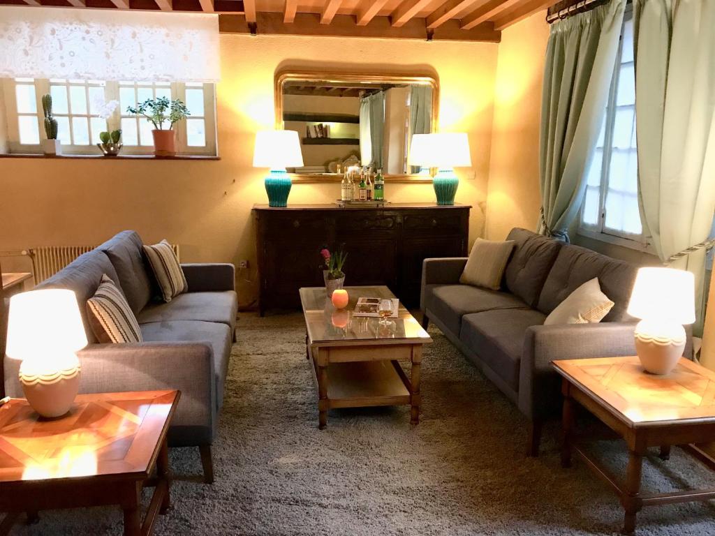 a living room with couches and tables and a mirror at Ancienne Auberge des Brizards - Morvan (14 personnes) in Quarré-les-Tombes