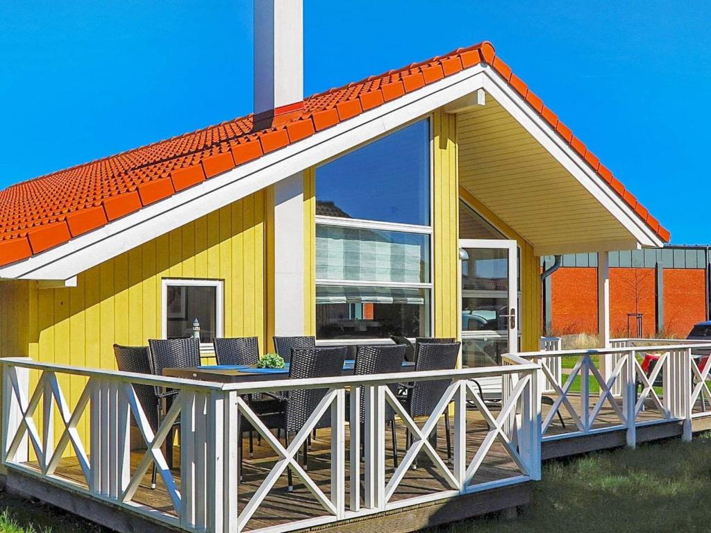 une maison avec une grande terrasse munie de chaises dans l'établissement 8 person holiday home in Gro enbrode, à Großenbrode