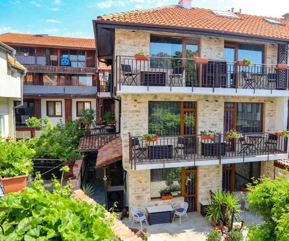 an apartment building with balconies and tables and chairs at Kirios Hotel in Nesebar