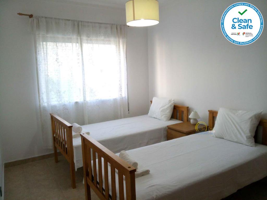 two beds in a small room with a window at Sol e Praia - Peniche II in Peniche