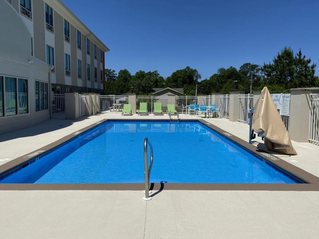 une piscine en face d'un bâtiment dans l'établissement Holiday Inn Express & Suites - Enterprise, an IHG Hotel, à Enterprise