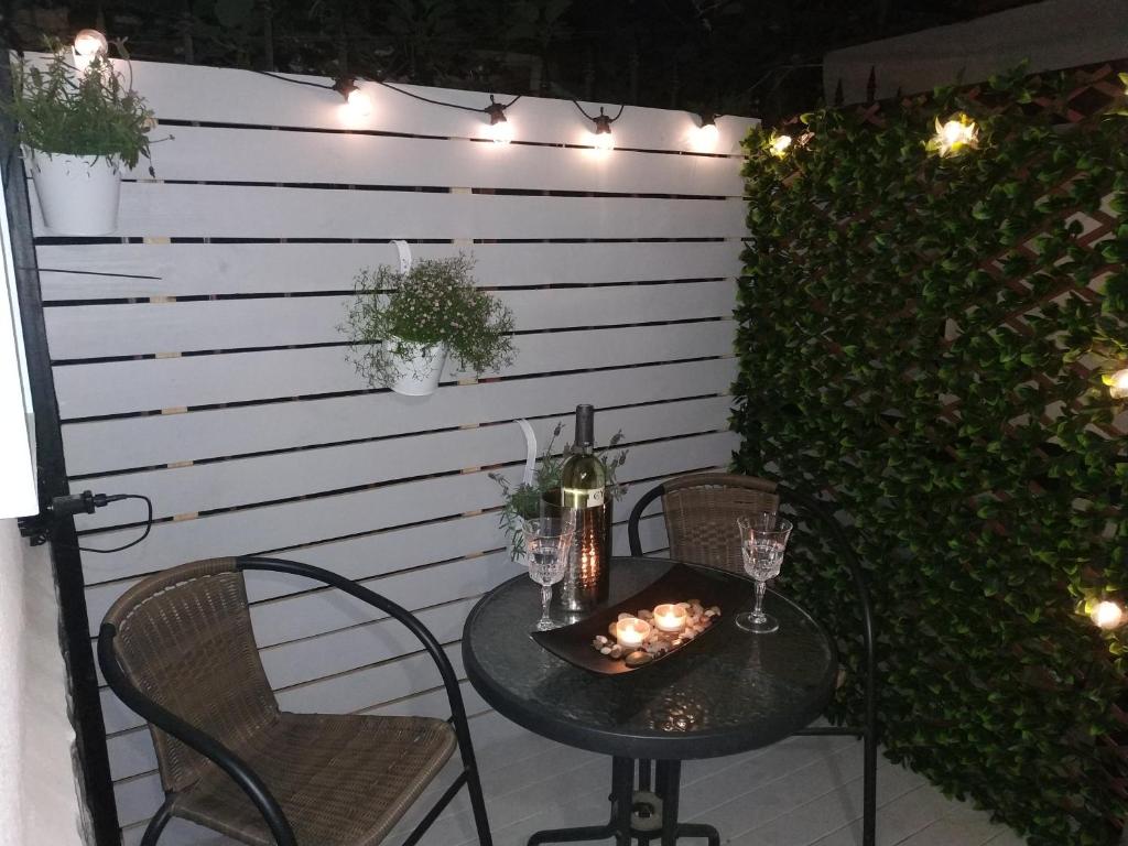 a table and chairs on a patio with lights at Rali Apartments in Kiten