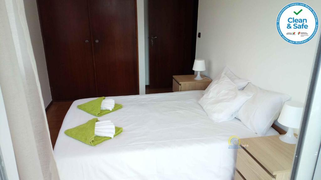 a bedroom with a white bed with two towels on it at Sol e Praia - Consolação I in Consolação