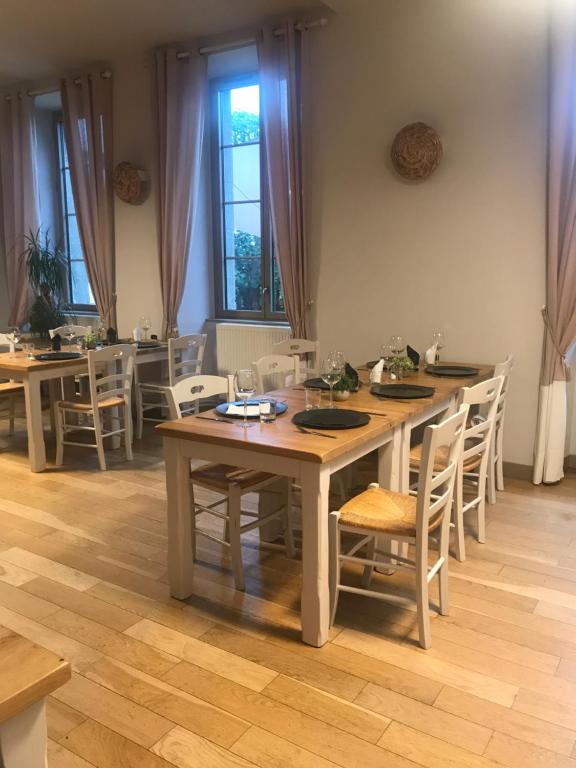 comedor con mesa de madera y sillas en Auberge de la fontaine aux loups en Saint-Sulpice-le-Dunois