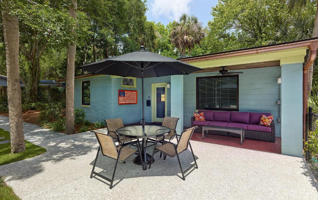 a table with chairs and an umbrella on a patio at Folly Vacation 202 Beach Bungalow in Folly Beach