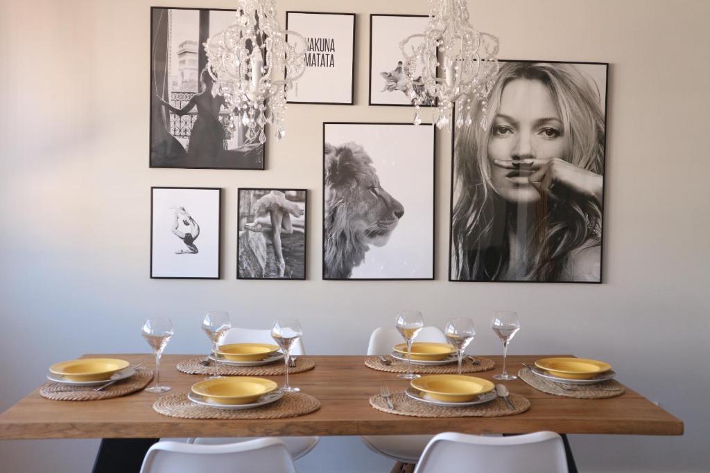 a dining room table with a bunch of pictures on the wall at FOROPLAZA Porta San Pedro Pleno Centro Vistas Muralla in Lugo