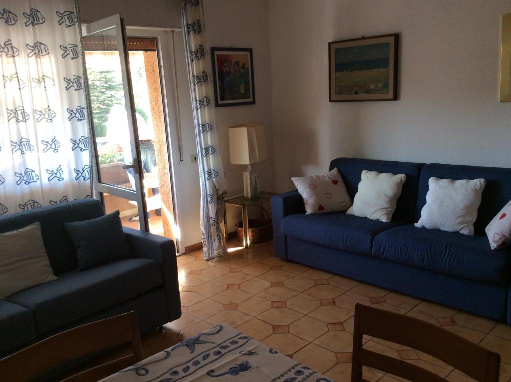 a living room with two blue couches and a window at La Residenza in Porto Azzurro