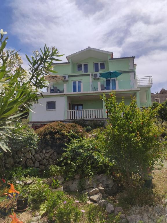 a house on top of a hill with bushes at Apartman Lapis in Savar