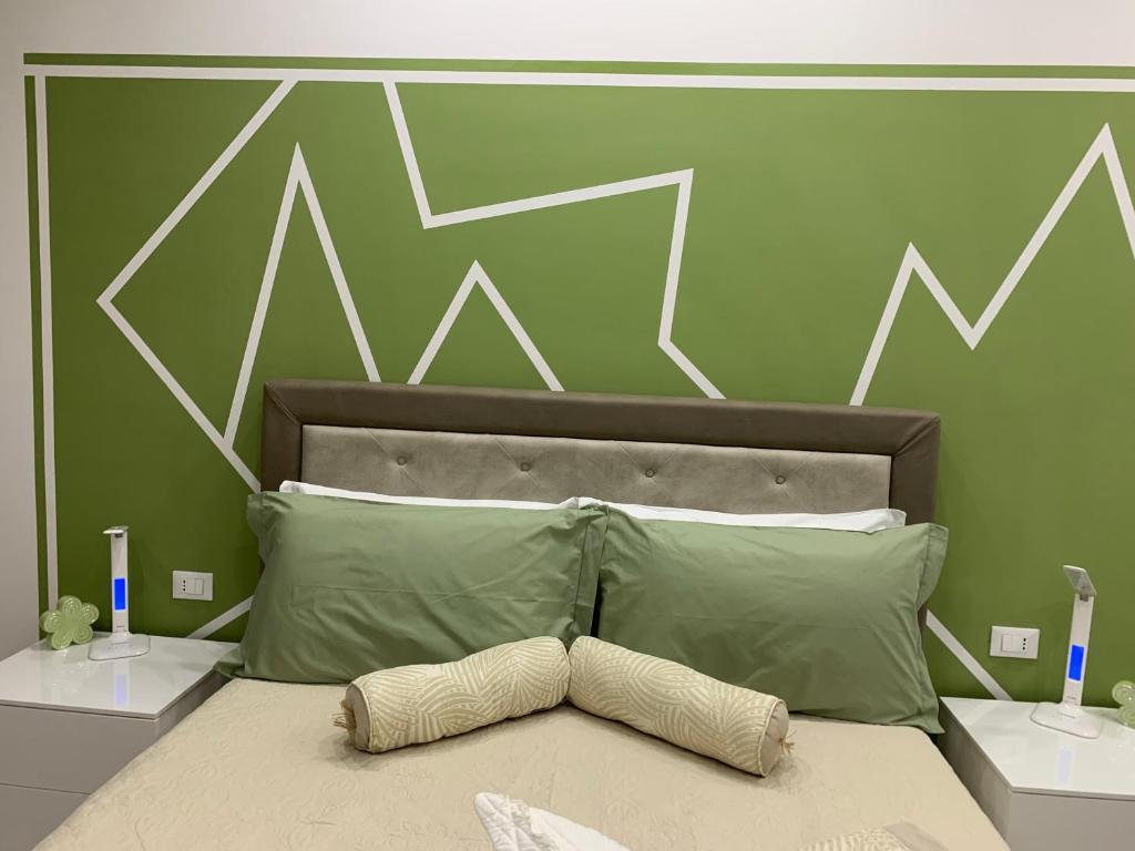 sypialnia z łóżkiem z zieloną i białą ścianą w obiekcie CEJM Apartments Merano w Meranie