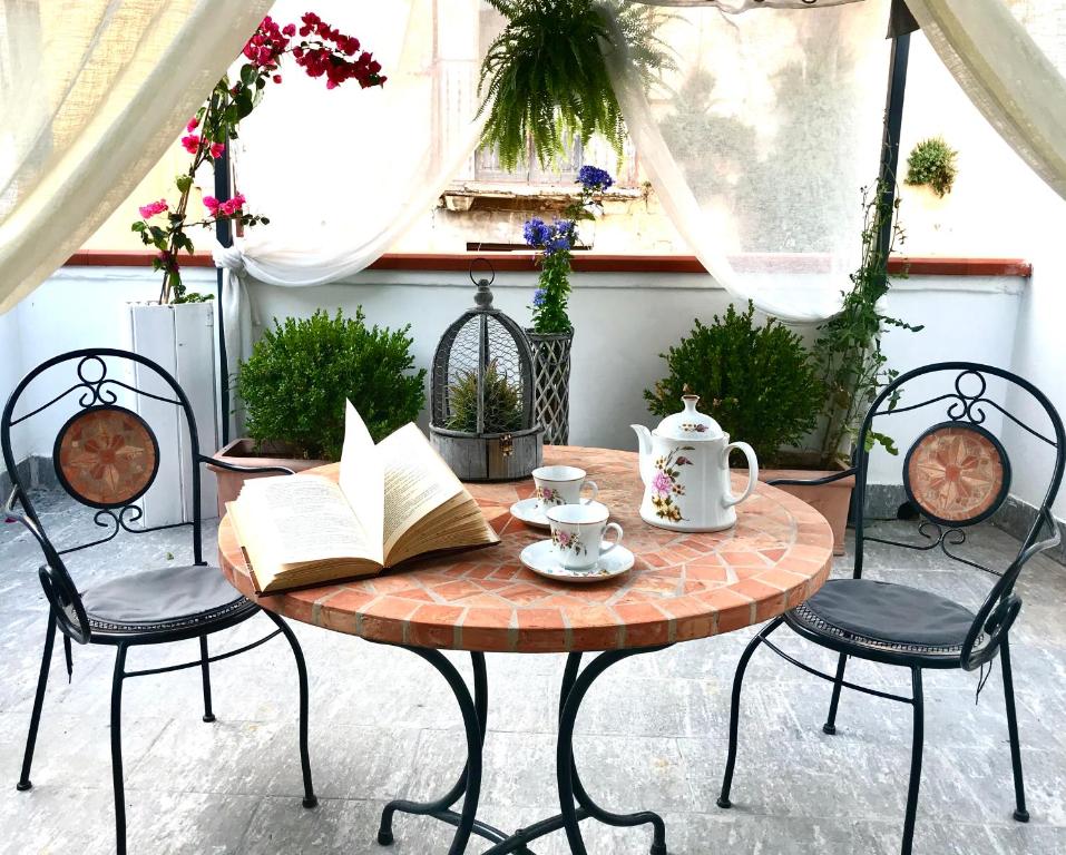 a table and chairs with a book and a cup of coffee at B&B Le Statuine in Barletta