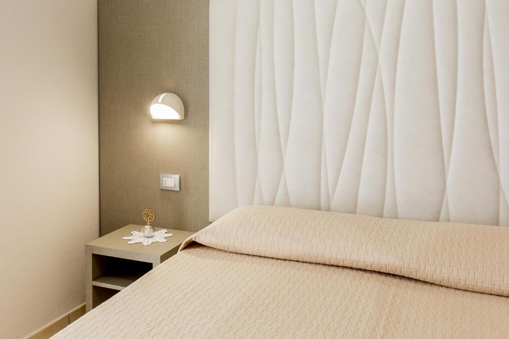 a bedroom with a bed with a large window at Hotel Roland in Riccione