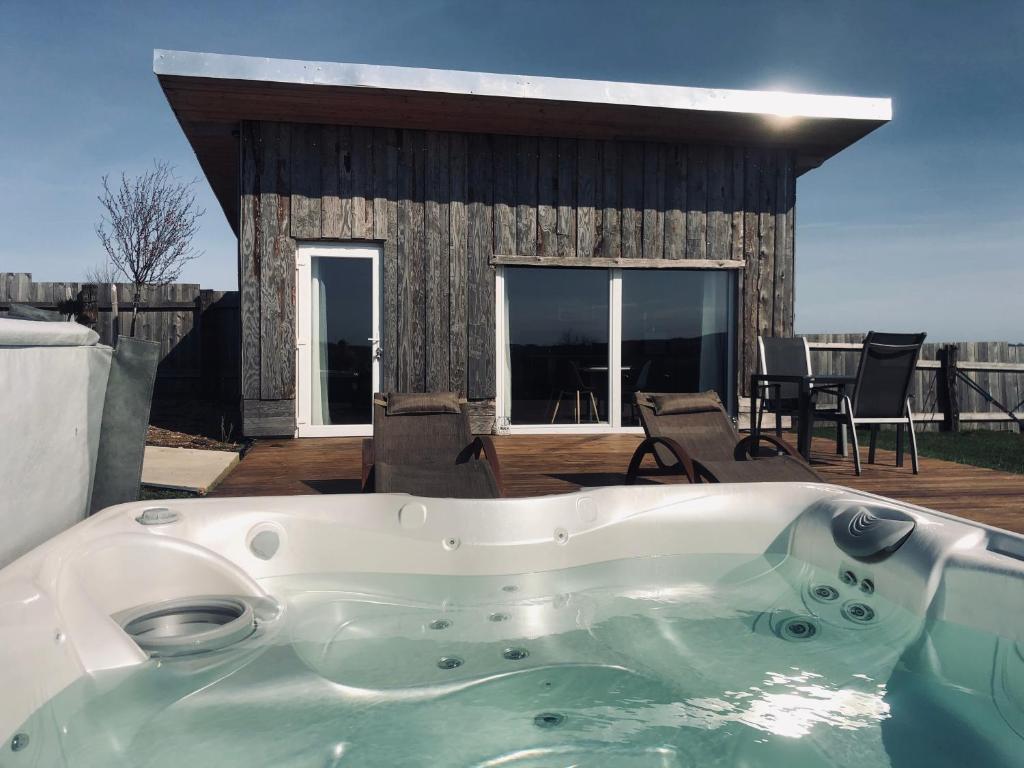 une baignoire en face d'une maison avec une terrasse. dans l'établissement Lodge spa, à Petit-Réderching