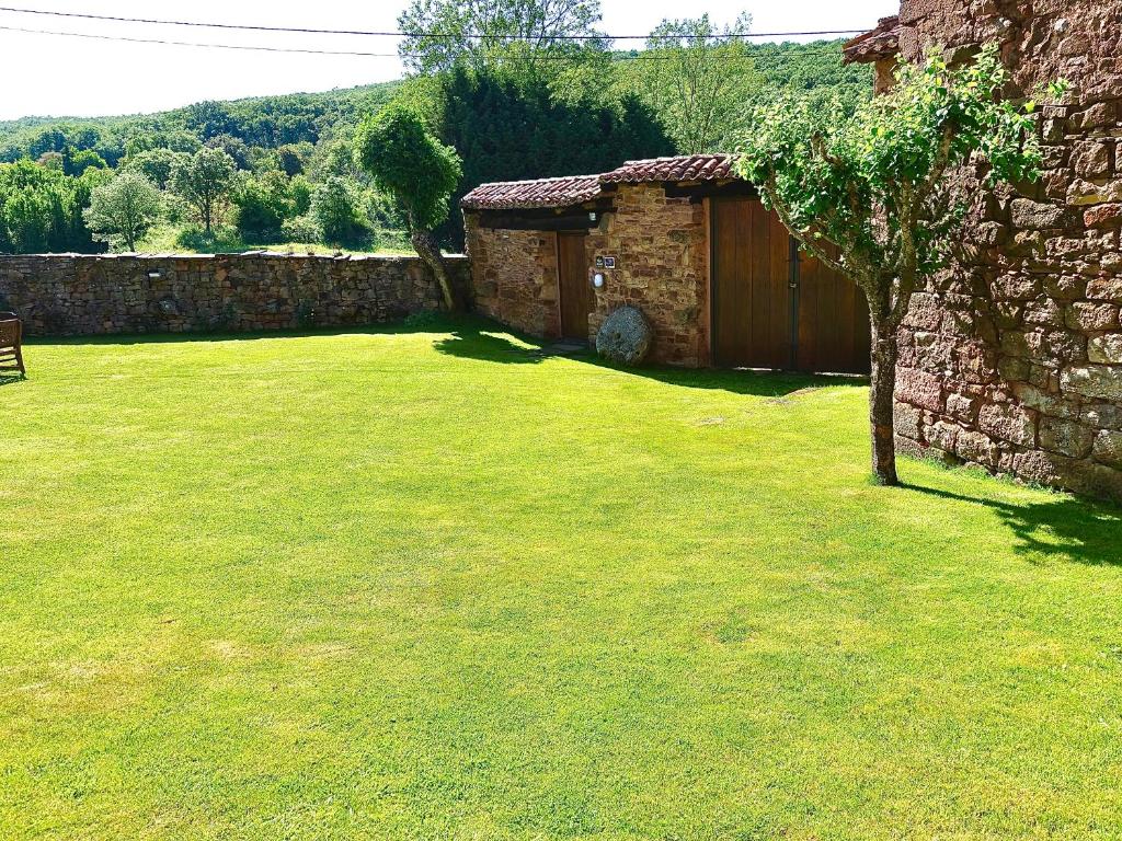 podwórze z kamiennym budynkiem i drzewem w obiekcie Casas Rurales El Mayorazgo w mieście Cordovilla de Aguilar